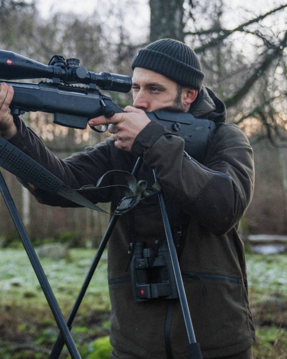 Pine Green Coloured Seeland Chaser Jacket on forest background #colour_pine-green