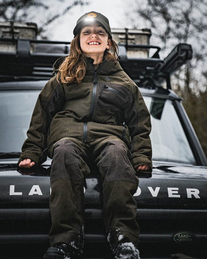 Pine Green coloured Seeland Childrens Skarn LED Junior Cap on forest background #colour_pine-green