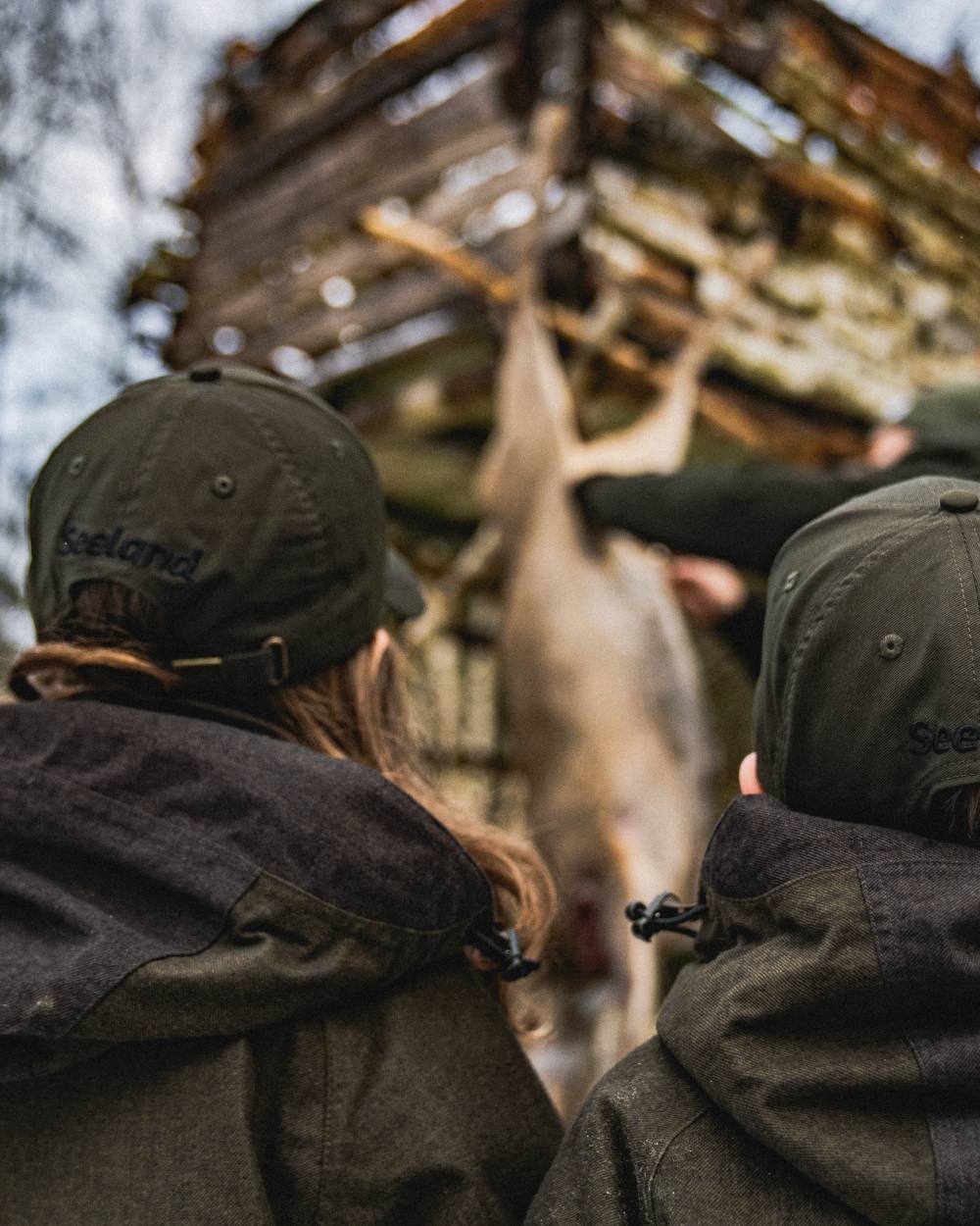 Pine Green coloured Seeland Childrens Skarn LED Junior Cap on forest background #colour_pine-green