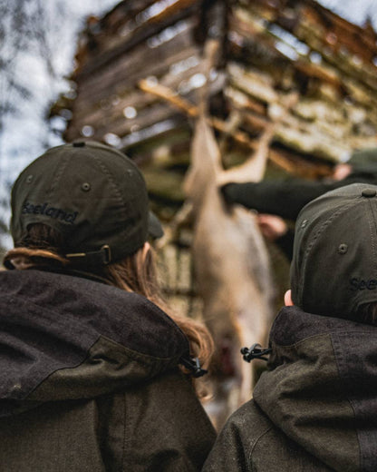 Pine Green coloured Seeland Childrens Skarn LED Junior Cap on forest background #colour_pine-green