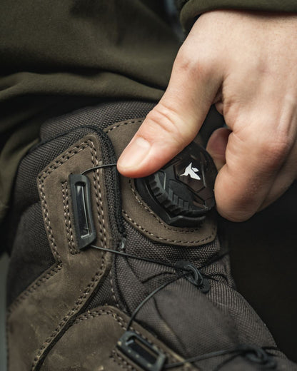 Dark Brown coloured Seeland Enduro Dial Mid Boots on forest background #colour_dark-brown