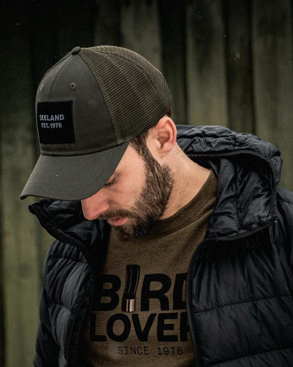 Grape Leaf Coloured Seeland Granite Trucker Cap on forest background #colour_grape-leaf