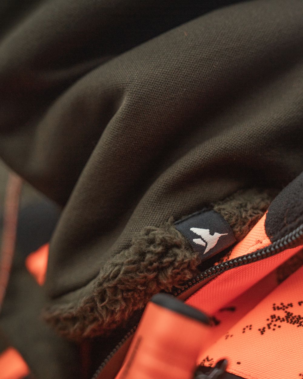 Pine Green coloured Seeland Iron Neckgaiter on forest background #colour_pine-green