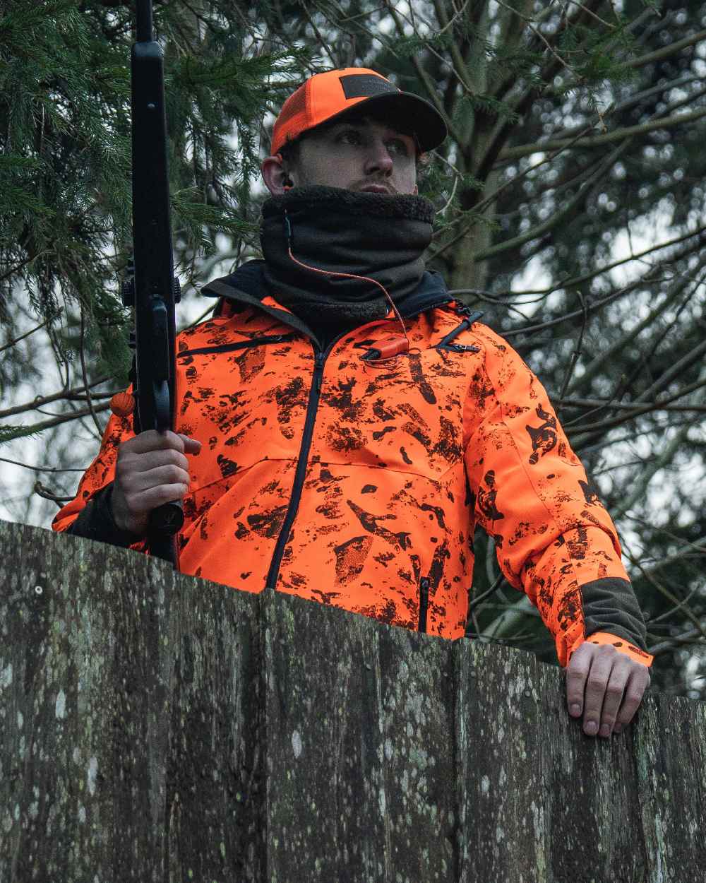 Pine Green coloured Seeland Iron Neckgaiter on forest background #colour_pine-green