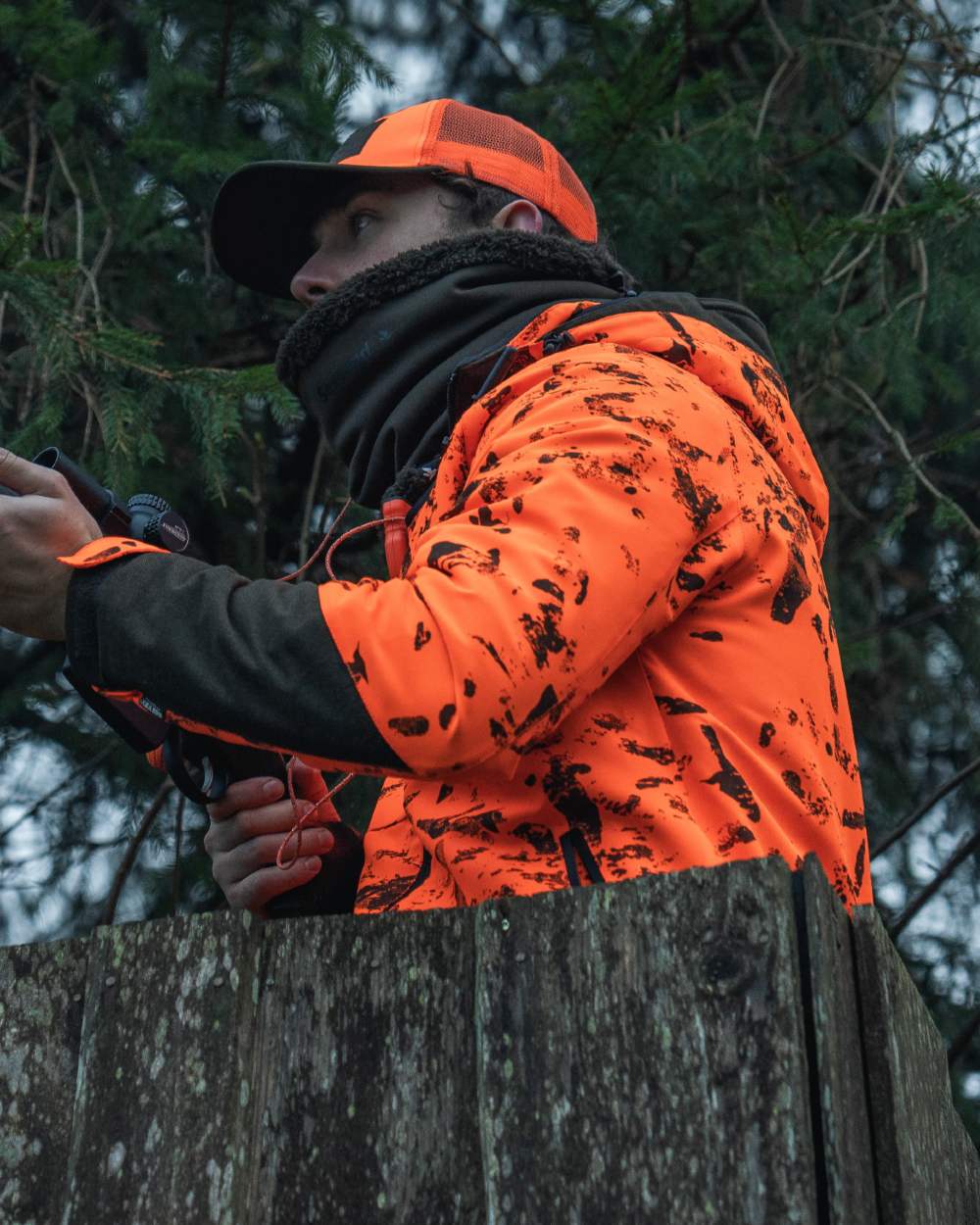 Pine Green coloured Seeland Iron Neckgaiter on forest background #colour_pine-green