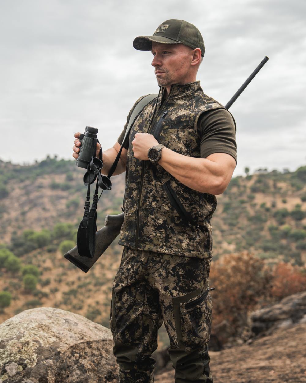 InVis MPC Green Coloured Seeland Mens Chaser Aero Camo Waistcoat on mountain background #colour_invis-mpc-green