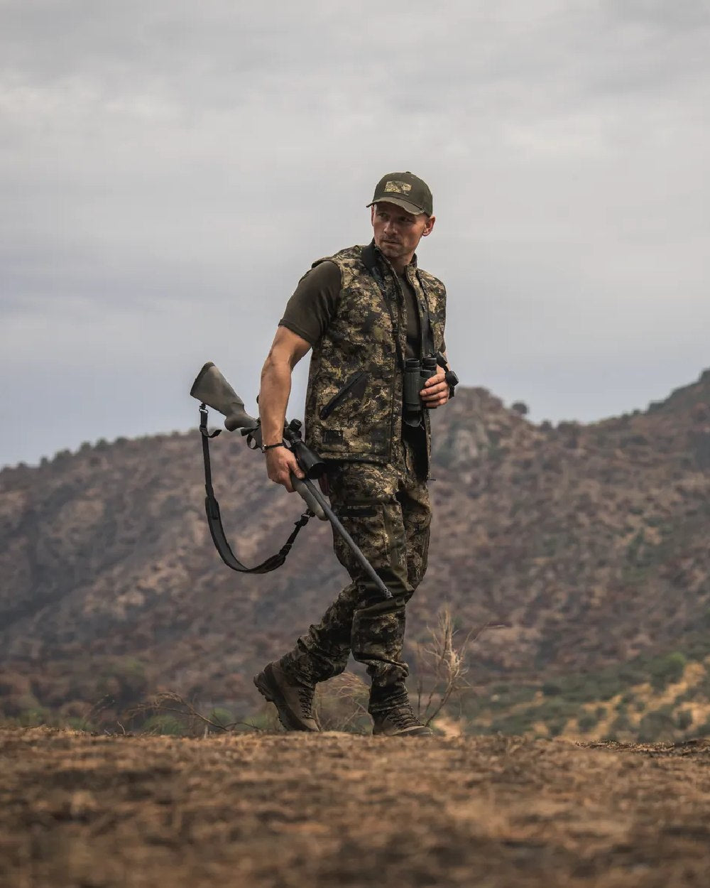InVis MPC Green Coloured Seeland Mens Chaser Aero Camo Waistcoat on mountain background #colour_invis-mpc-green