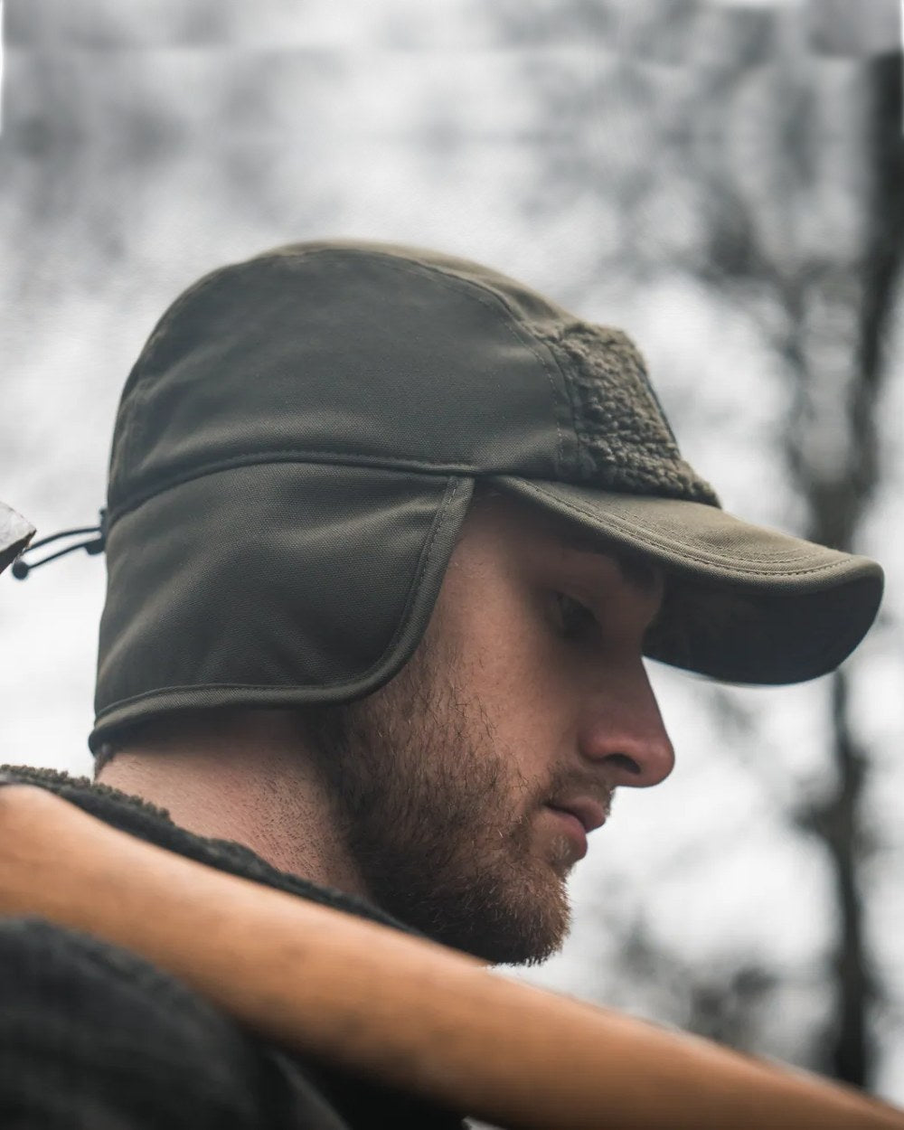 Pine Green coloured Seeland Mens Teddy Fold Down Cap on forest background #colour_pine-green