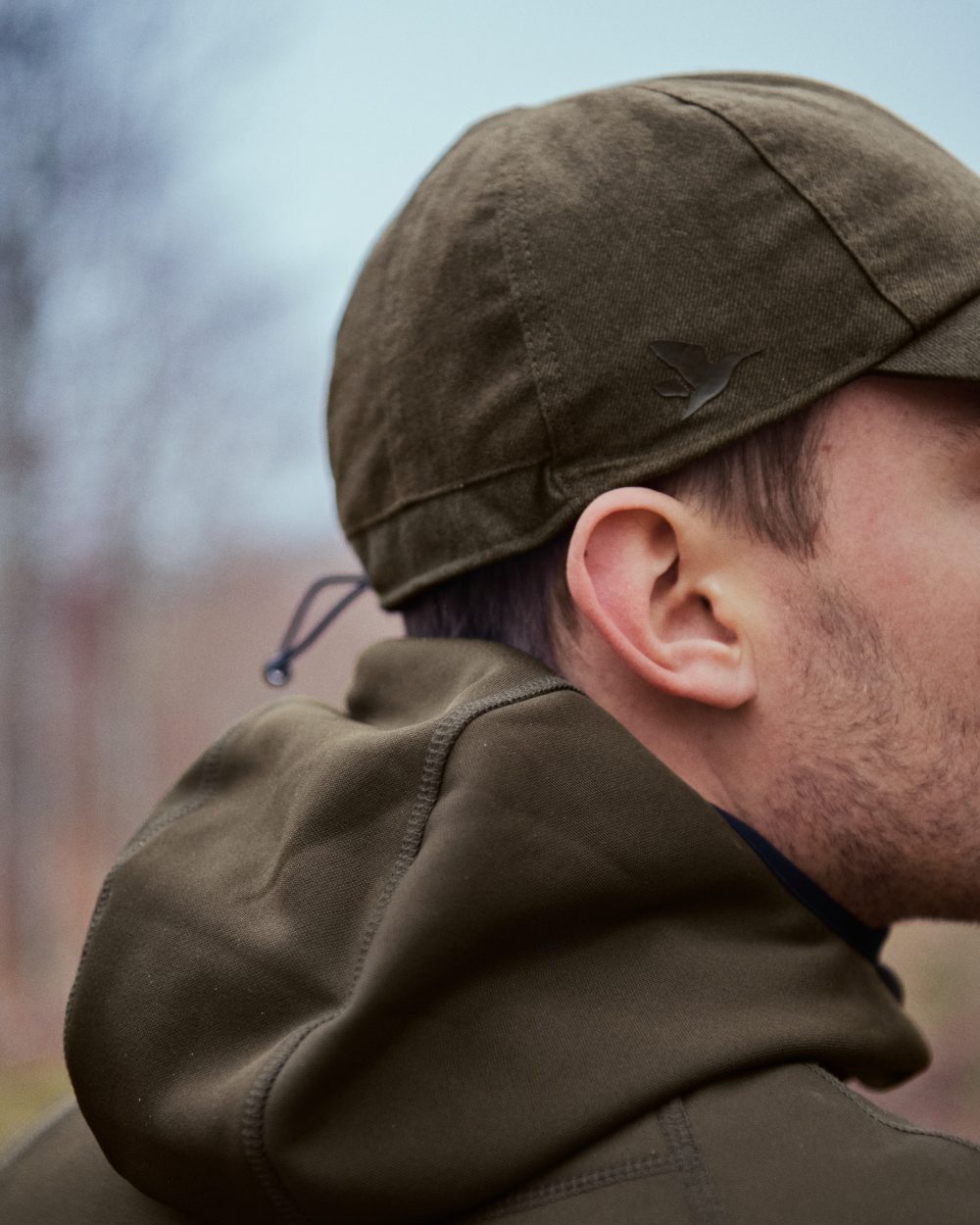 Pine Green coloured Seeland Power Fleece on forest background #colour_pine-green