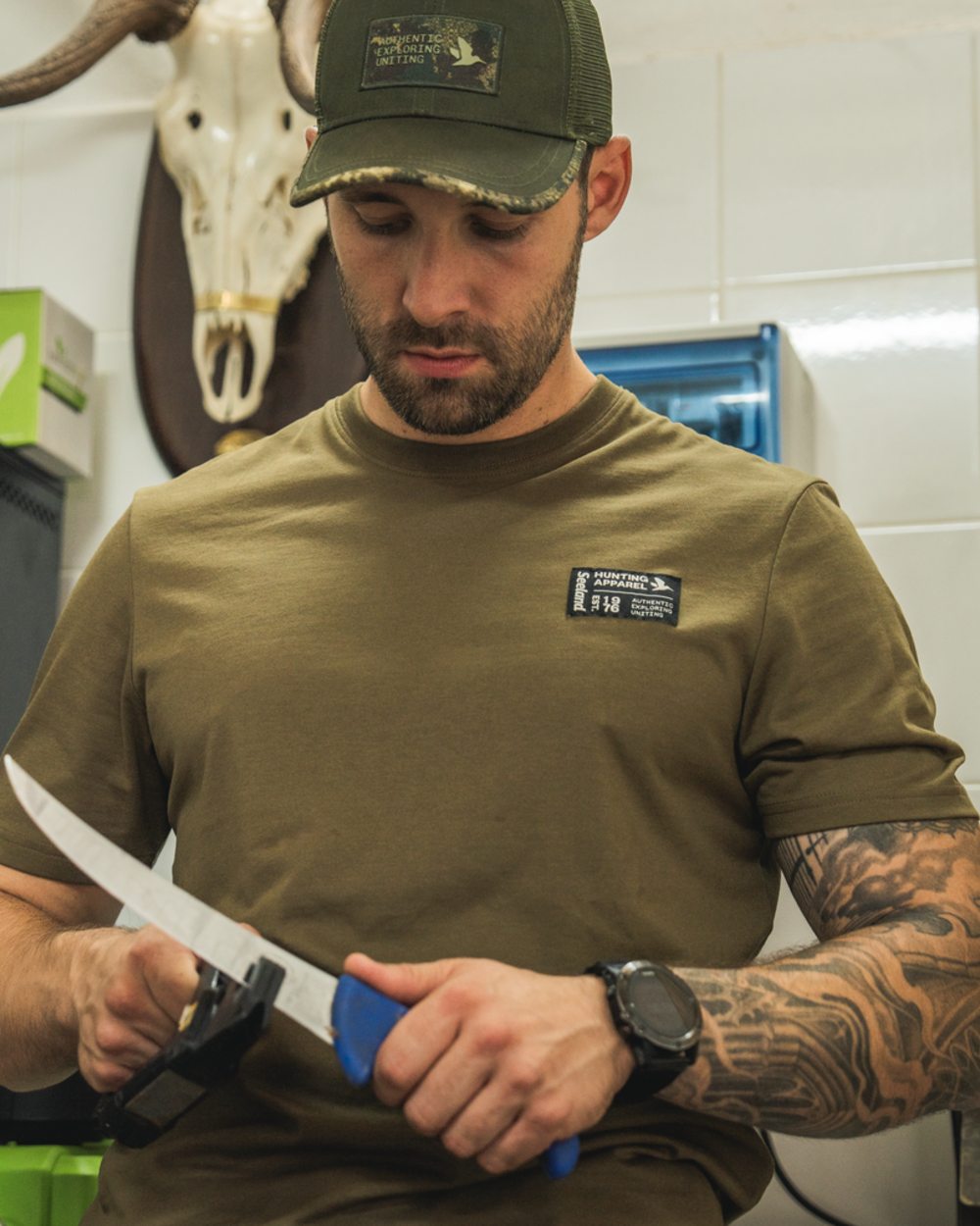 Military Olive Coloured Seeland Striker T-Shirt on indoor background #colour_military-olive