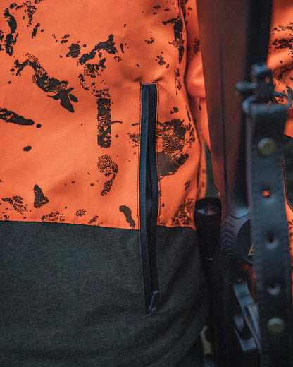 Orange Blaze InVis MPC coloured Seeland Trax Blaze Jacket on forest background #colour_orange-blaze-invis-mpc