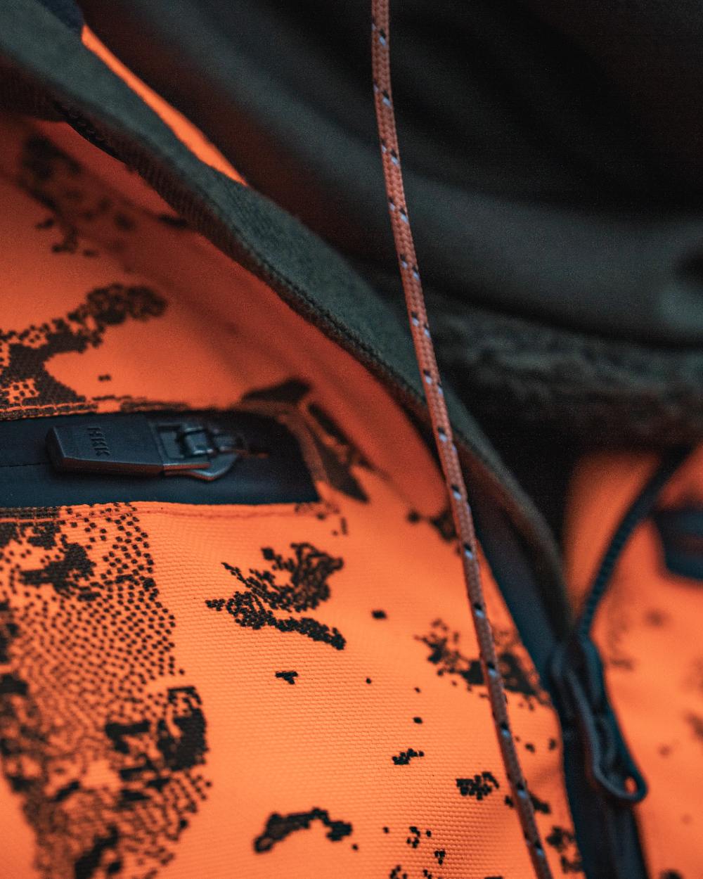 Orange Blaze InVis MPC coloured Seeland Trax Blaze Jacket on forest background #colour_orange-blaze-invis-mpc