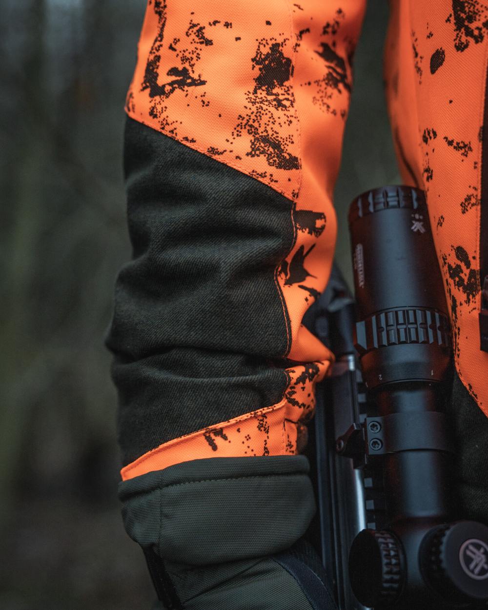 Orange Blaze InVis MPC coloured Seeland Trax Blaze Jacket on forest background #colour_orange-blaze-invis-mpc