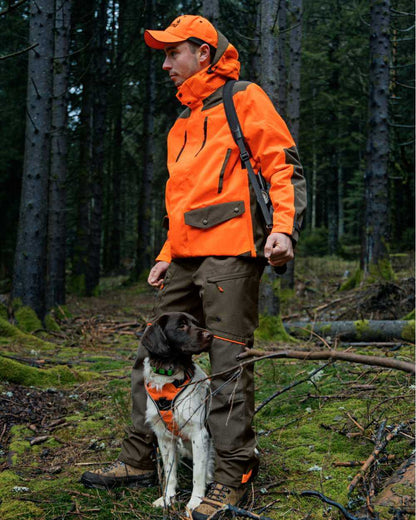 Pine Green Hi-Vis Orange Coloured Seeland Venture Rover Jacket on forest background #colour_pine-green-hi-vis-orange