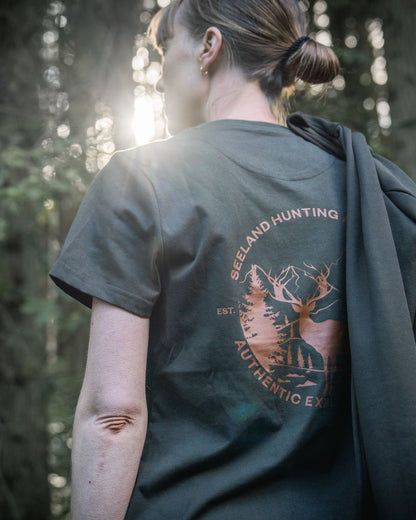 Pine Green Coloured Seeland Womens Hunting Heritage T-Shirt on forest background #colour_pine-green