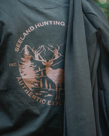 Pine Green Coloured Seeland Womens Hunting Heritage T-Shirt on forest background #colour_pine-green