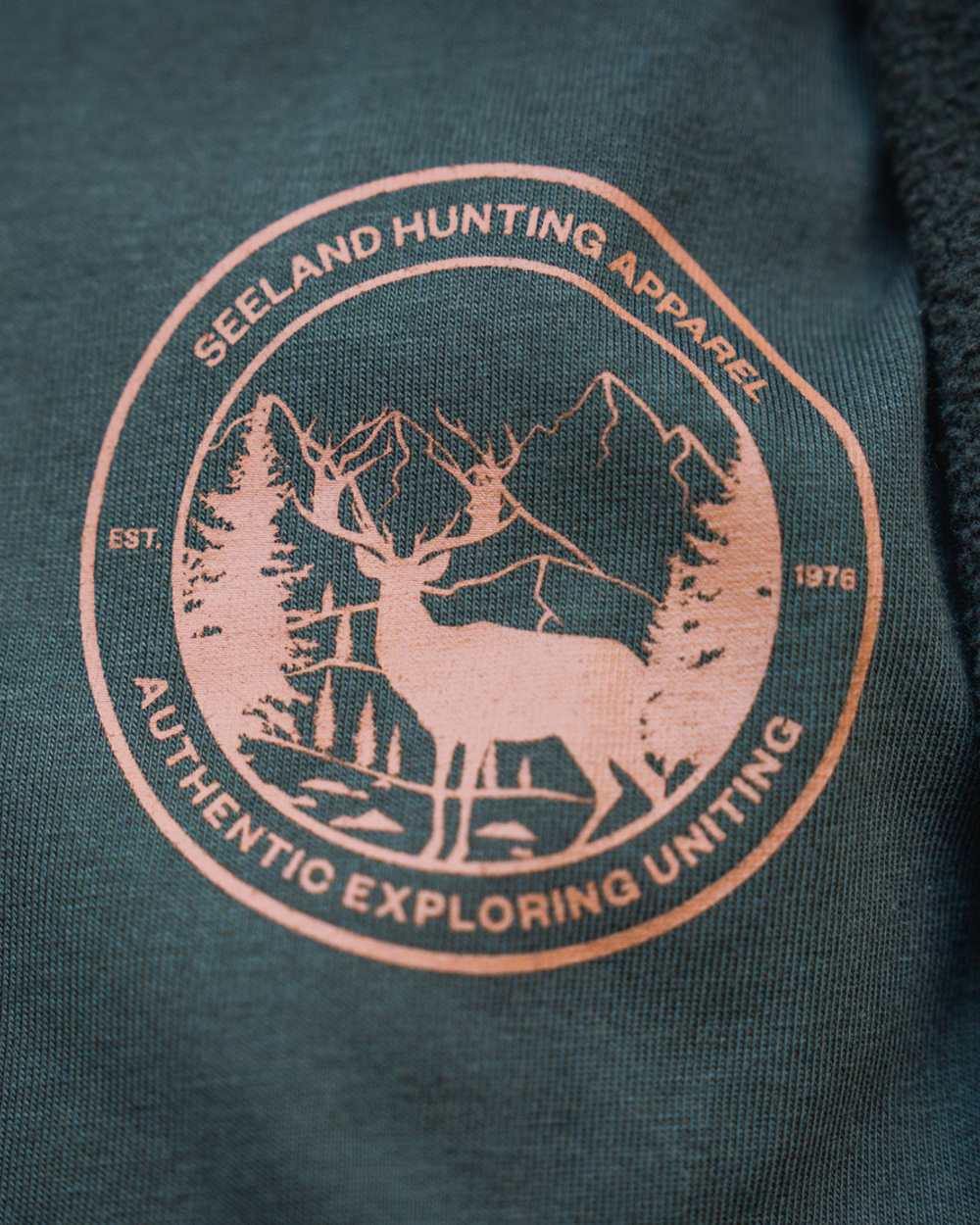 Pine Green Coloured Seeland Womens Hunting Heritage T-Shirt on forest background #colour_pine-green
