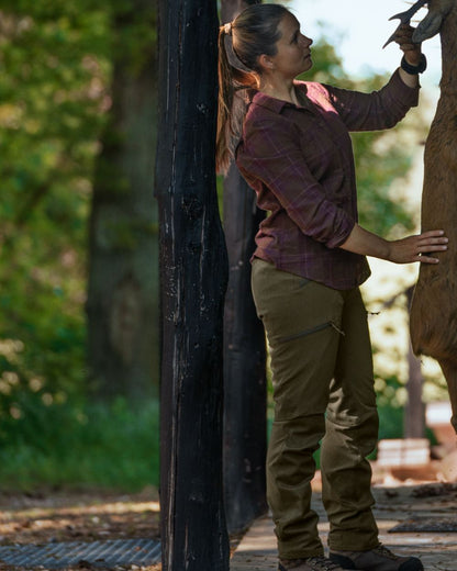 Pine Green coloured Seeland Womens Larch Membrane Trousers on forest background #colour_pine-green