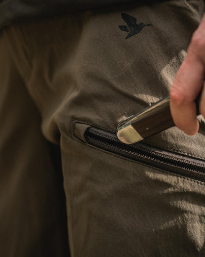 Pine Green Chocolate Torte coloured Seeland Womens Larch Stretch Trousers on forest background #colour_pine-green-chocolate-torte