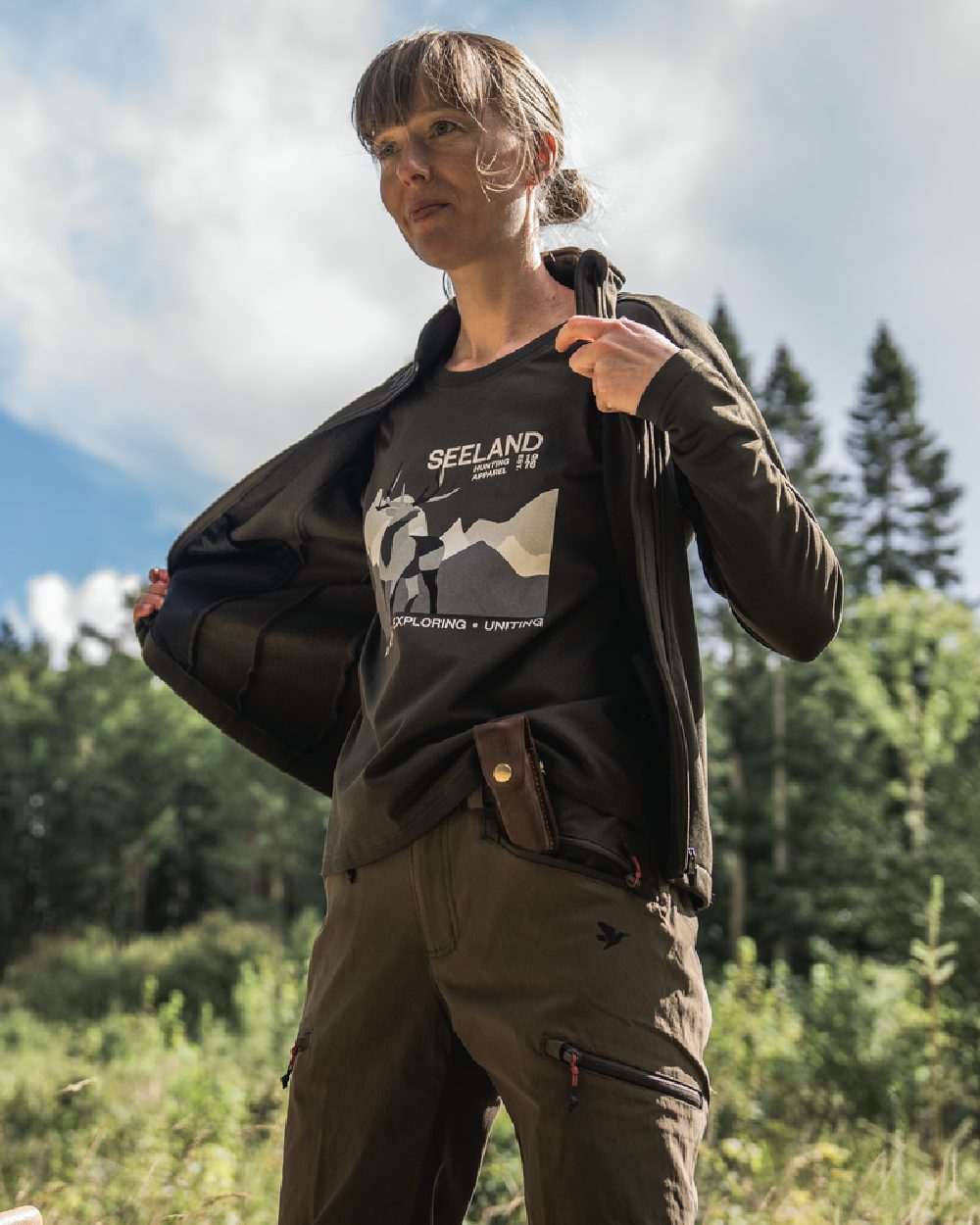 Pine Green Coloured Seeland Womens Sadie T-Shirt on forest background #colour_pine-green