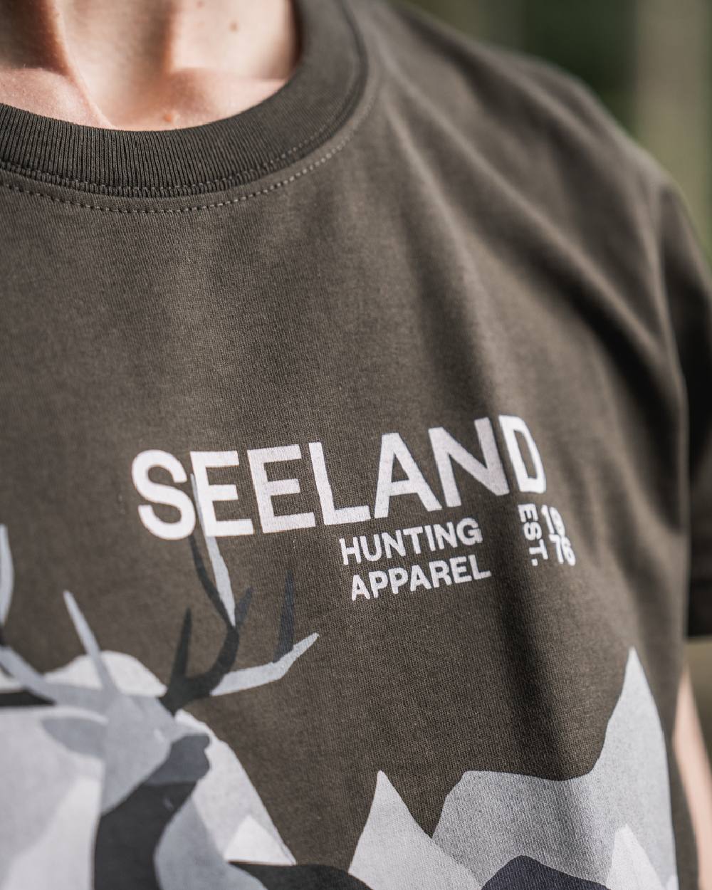 Pine Green Coloured Seeland Womens Sadie T-Shirt on blurry background #colour_pine-green