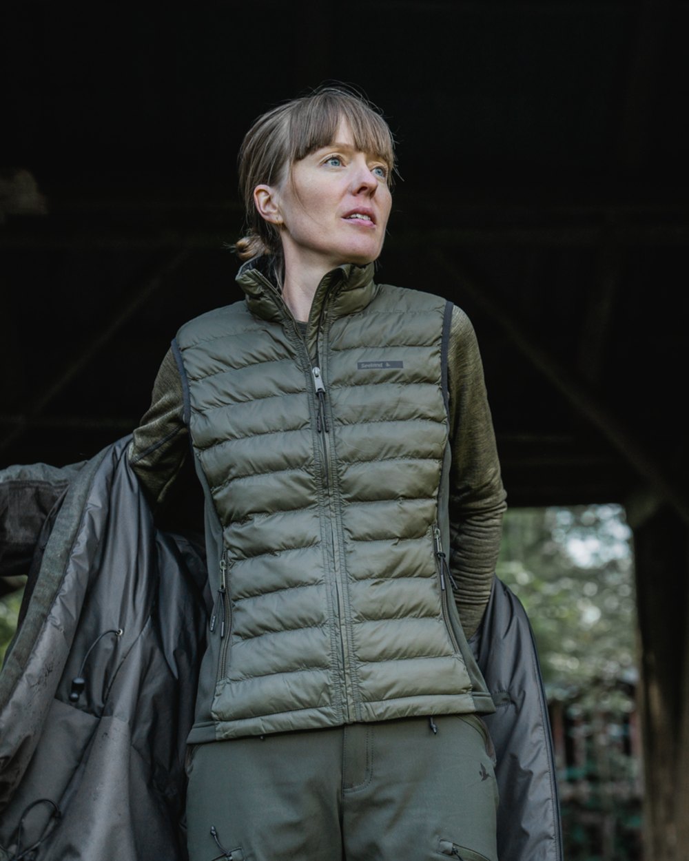 Light Pine Coloured Seeland Womens Therma Waistcoat on forest background #colour_light-pine