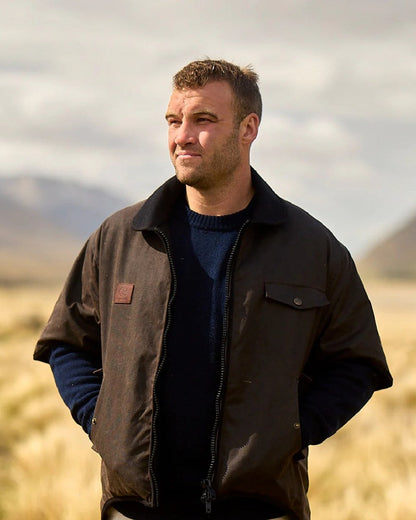 Brown Coloured Swanndri Mens 3/4 Sleeve Oilskin Jacket on field background #colour_brown