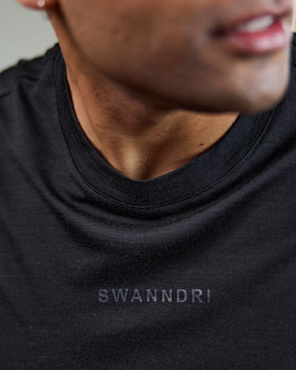Black Coloured Swanndri Mens Merino Fusion T-Shirt on blurry background #colour_black