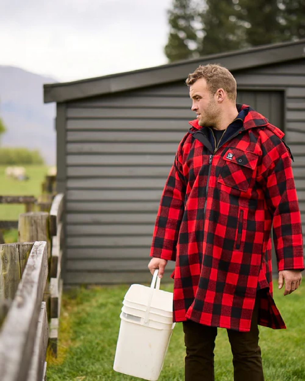 Red Black Check Coloured Swanndri Mens Mosgiel Wool Bushshirt with Zip-up Front on countryside background #colour_red-black-check