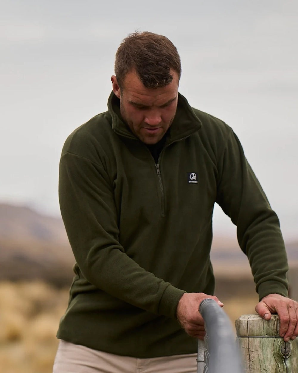 Olive Coloured Swanndri Mens Motu Fleece Pullover on blurry background #colour_olive