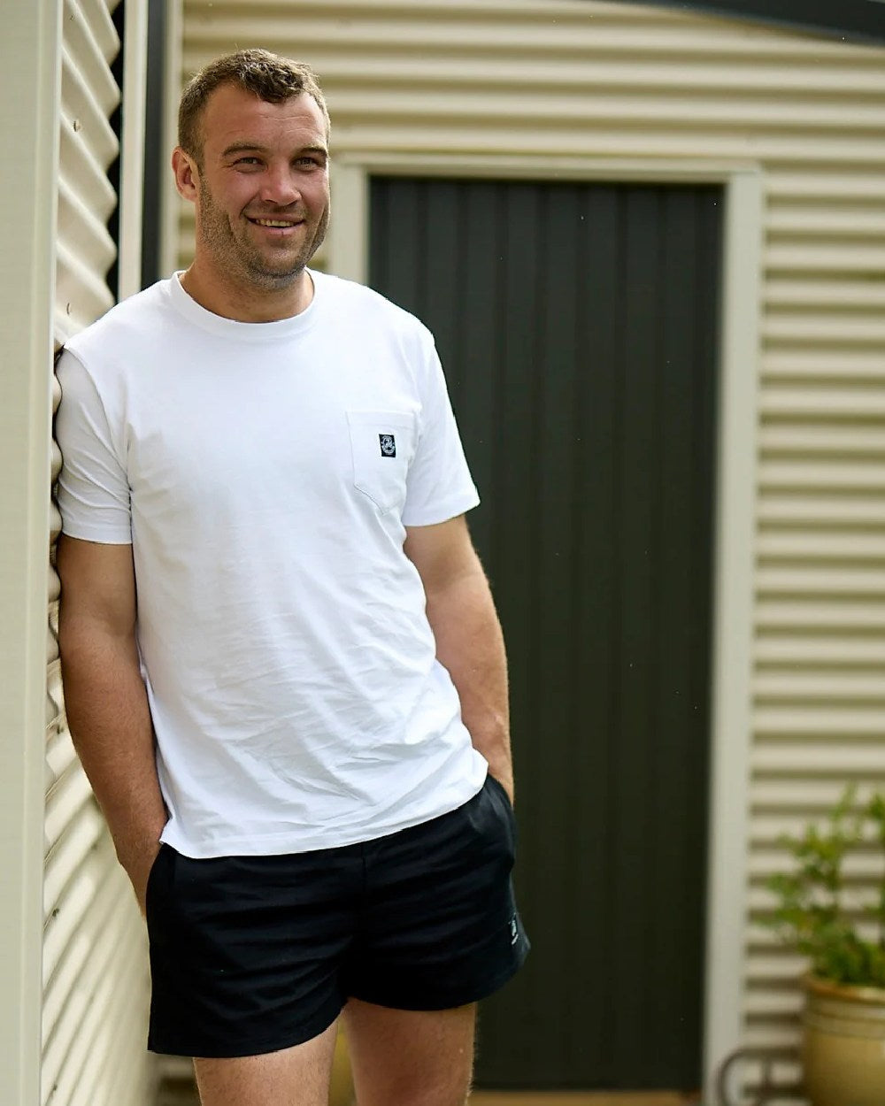 Black Coloured Swanndri Mens Rugby Short on door background #colour_black
