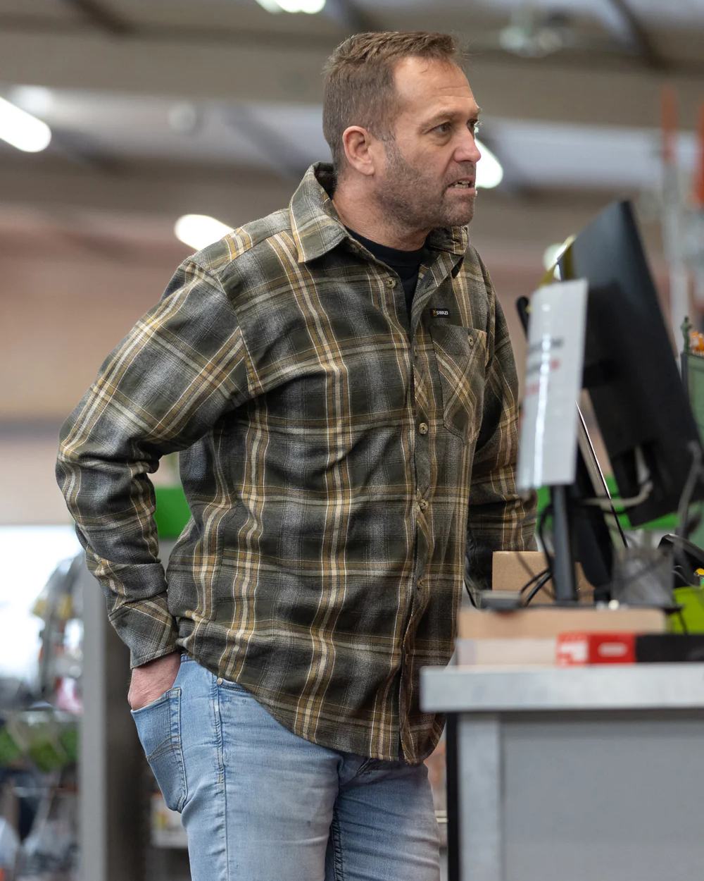 Olive coloured Swazi Grafter Shirt on blurry background #colour_olive