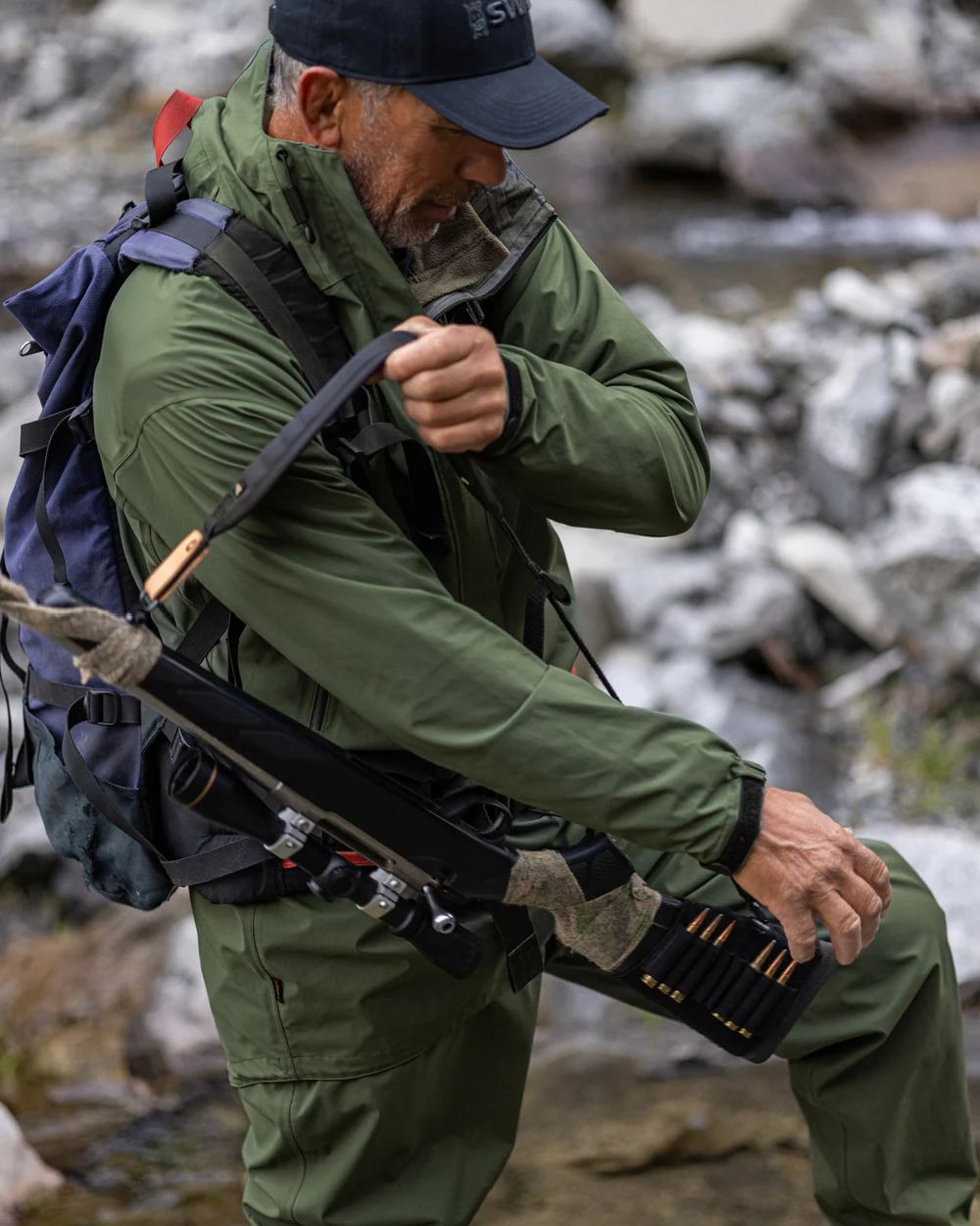 Olive coloured Swazi Mens Rifleman Ultralite Overpants on rock background #colour_olive