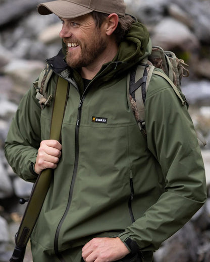 Olive coloured Swazi Mens Sentinel Ultralight Jacket on rock background #colour_olive