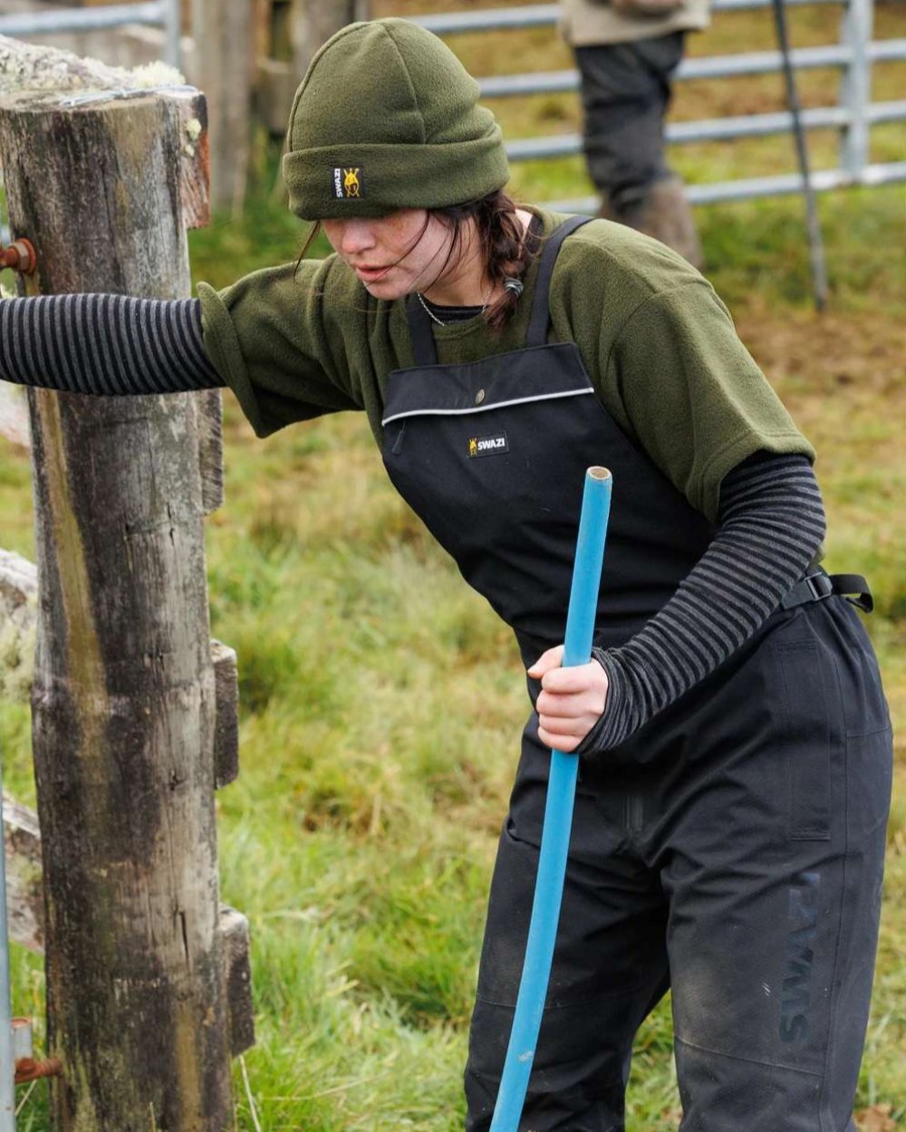 Black coloured Swazi Mens Torrent Bib Overpants on fences background #colour_black
