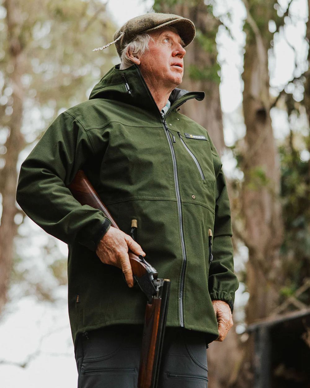 Olive coloured Swazi The Ibex Jacket on blurry background #colour_olive