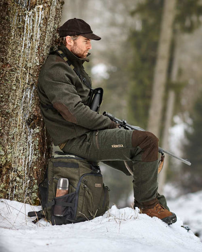 Hunting Green Coloured Harkila Metso Rucksack Chair Backpack on snow background #colour_hunting-green