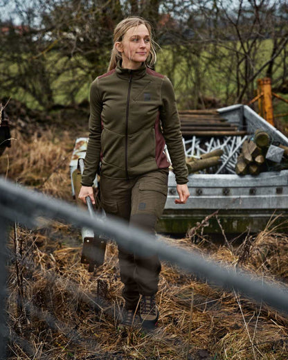 Willow Green Deep Brown Coloured Harkila Womens Scandinavian Pants On A Forest Background #colour_willow-green-deep-brown