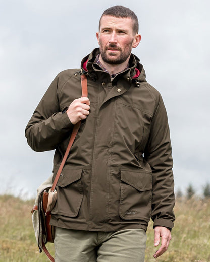 Fen Green Coloured Hoggs of Fife Culloden Waterproof Field Jacket on forest background #colour_fen-green