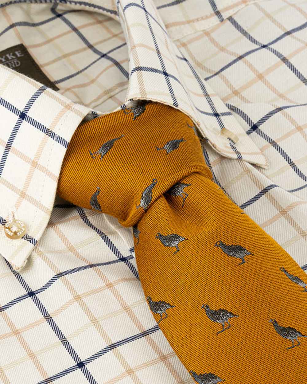 Mustard coloured Jack Pyke Silk Tie Partridge on shirt background #colour_mustard