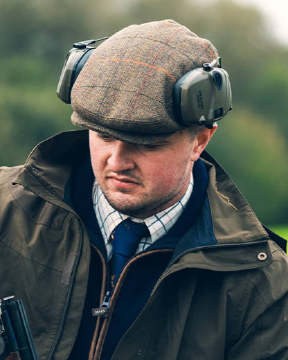 Tweed Brown Coloured Jack Pyke Wool Blend Tweed Flat Cap On A Blurry Background #colour_tweed-brown