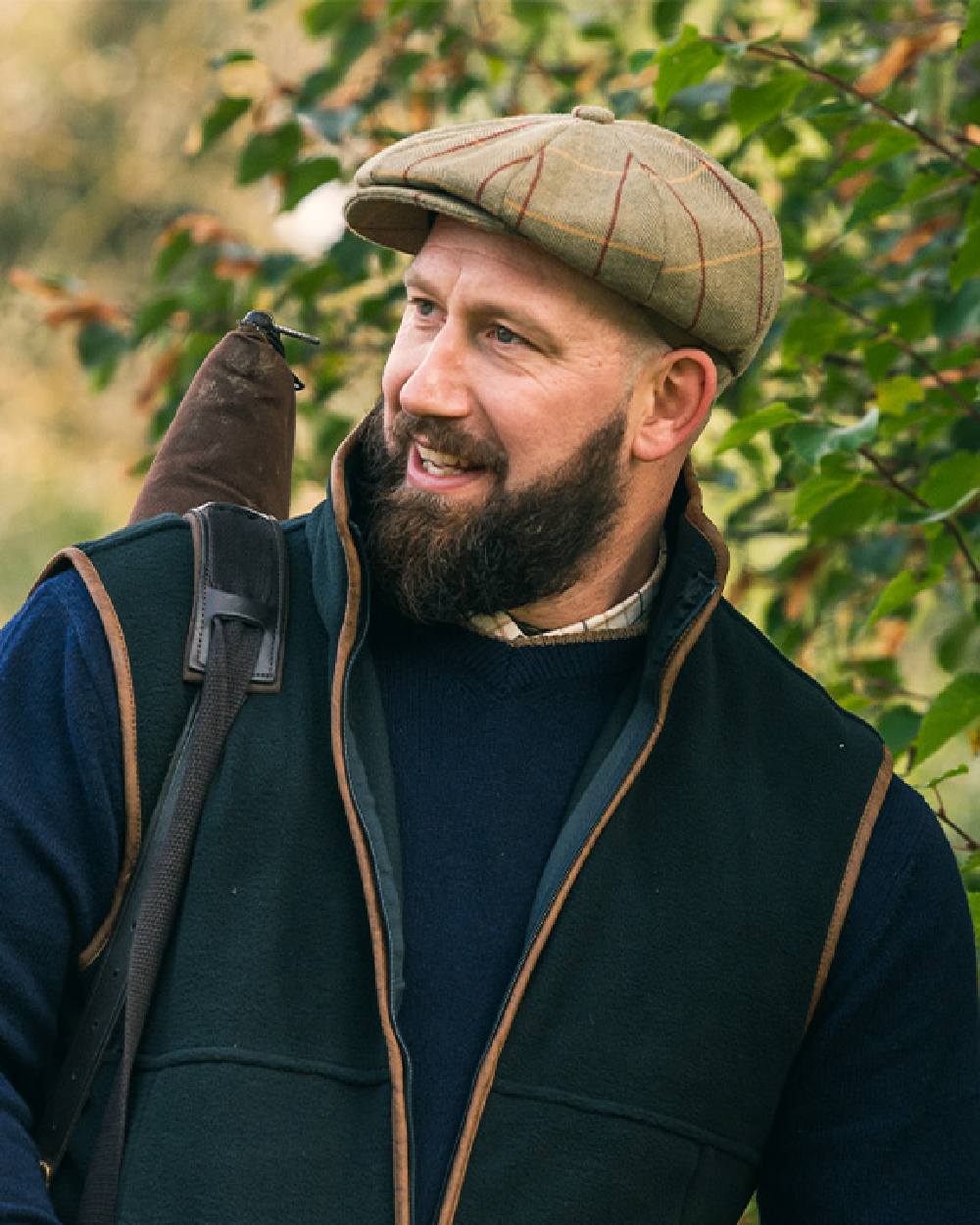 Tweed Green Coloured Jack Pyke Wool Blend Tweed Flat Cap On Leafy Background #colour_tweed-green