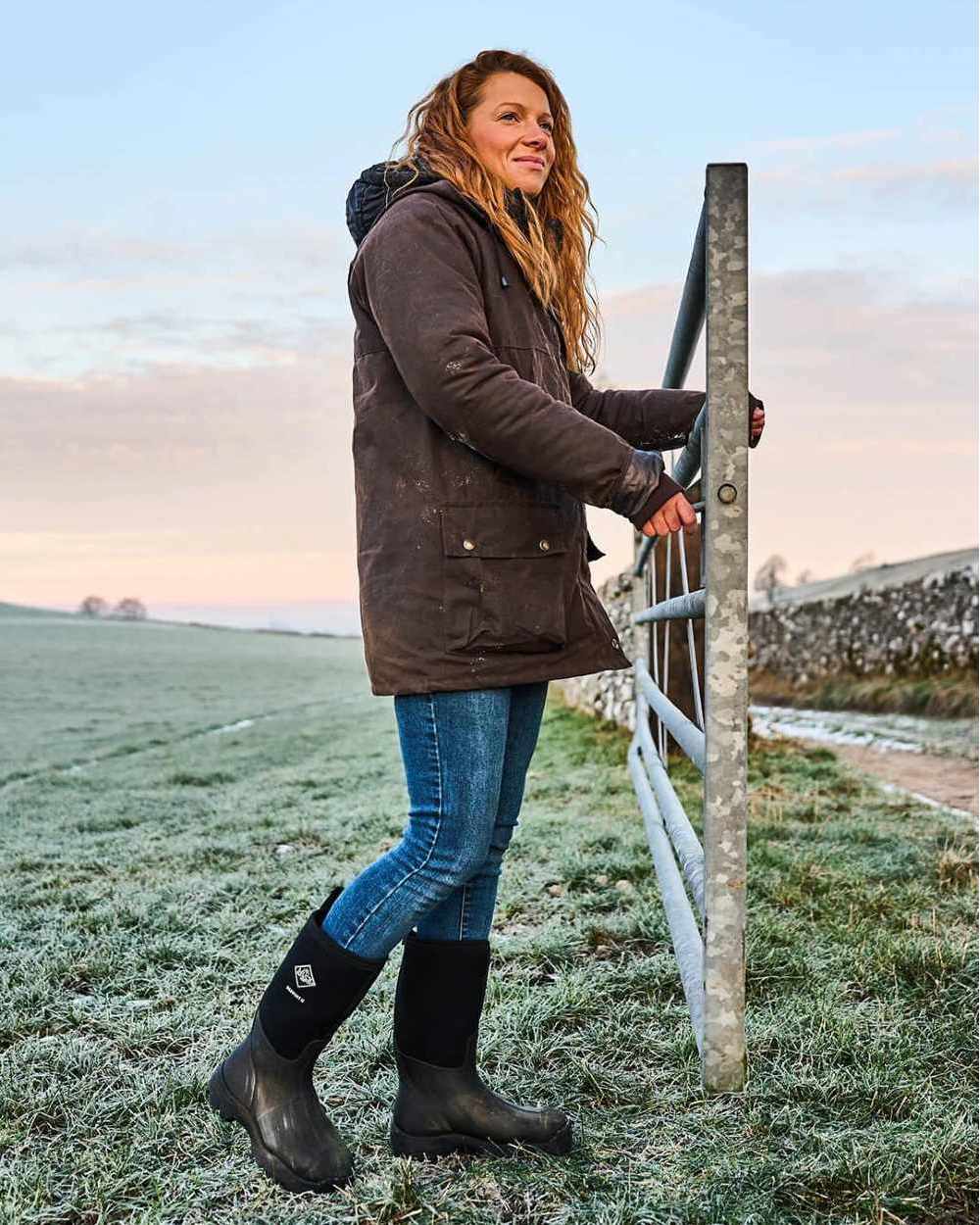 Black Coloured Muck Boots Derwent II Wellingtons On A Field Background #colour_black