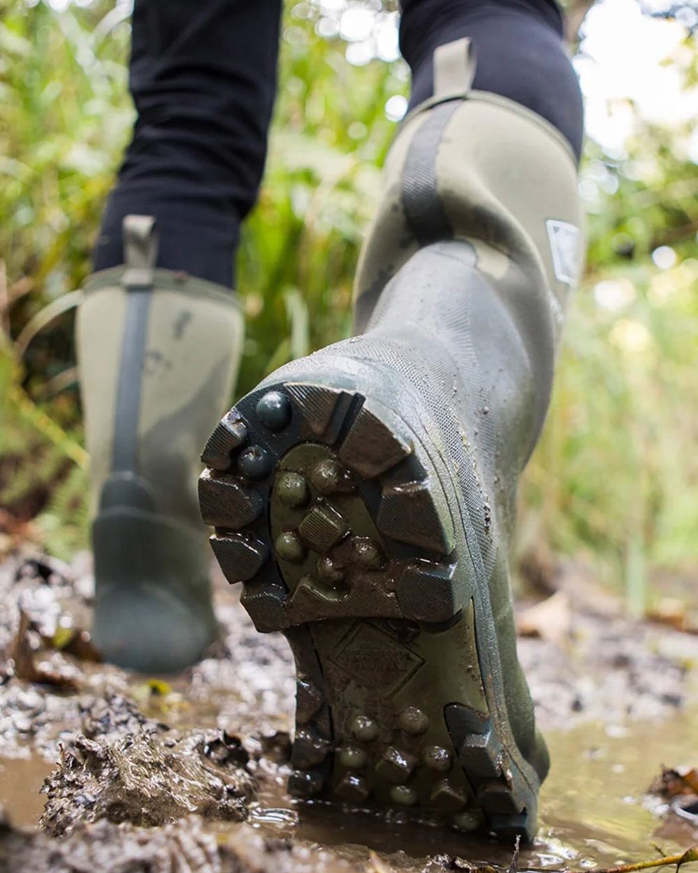 Moss Coloured Muck Boots Derwent II Wellingtons On A Forest Background #colour_moss
