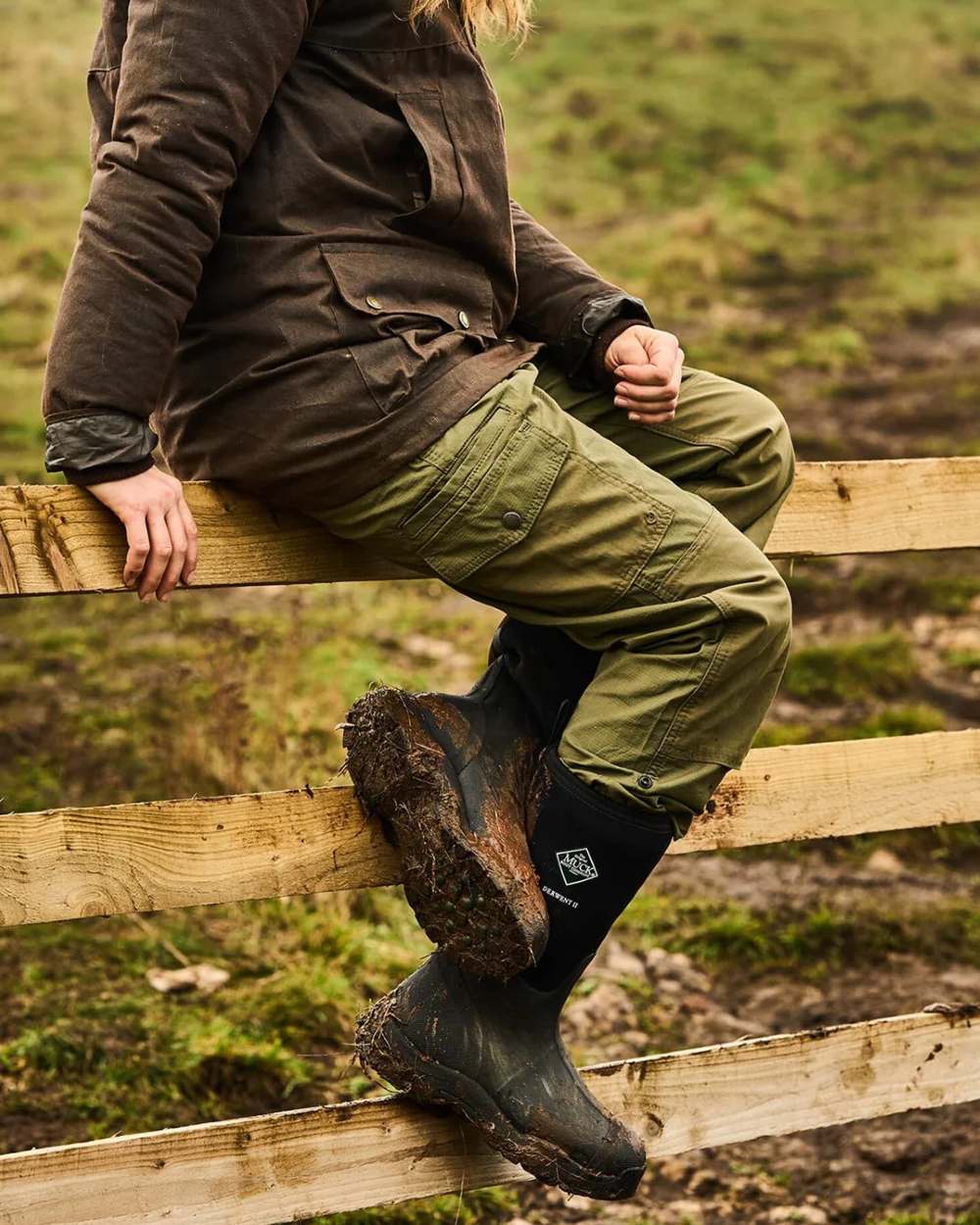Black Coloured Muck Boots Derwent II Wellingtons On A Forest Background #colour_black