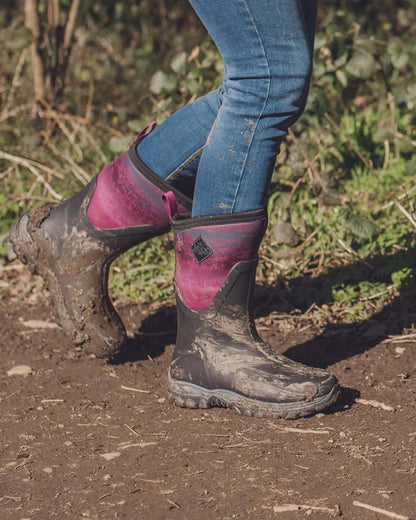 Magenta Digi Fade Print Coloured Muck Boots Womens Arctic Sport II Mid Wellingtons On A Field Background #colour_magenta-digi-fade-print