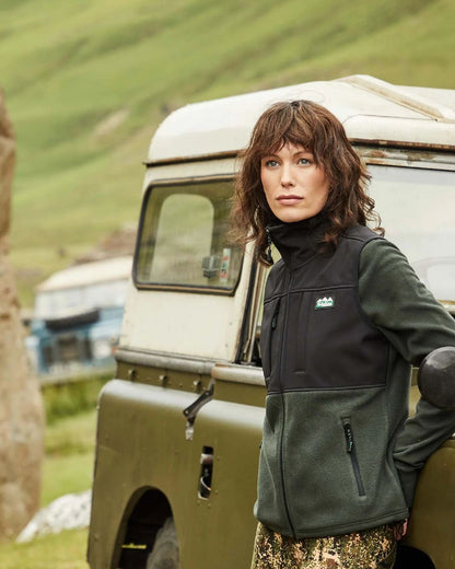 Olive Black Coloured Ridgeline Ladies Hybrid Fleece Vest On A Hill Background #colour_olive-black