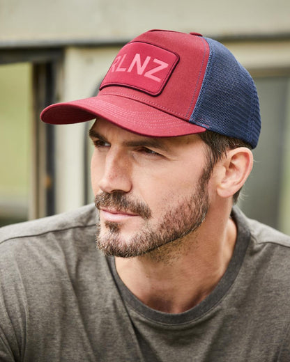 Rhubarb Coloured Ridgeline RLNZ Trucker Cap On A Street Background #colour_rhubarb